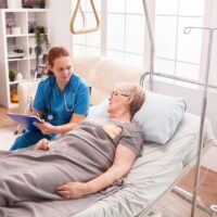 Senior woman lying in nursing home bed Senior woman lying in nursing home bed